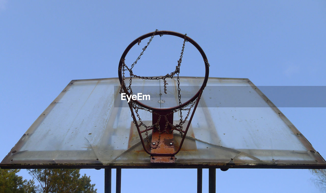 LOW ANGLE VIEW OF BASKETBALL HOOP AGAINST BLUE SKY