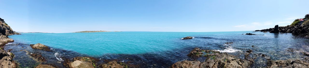 Panoramic view of sea against clear blue sky