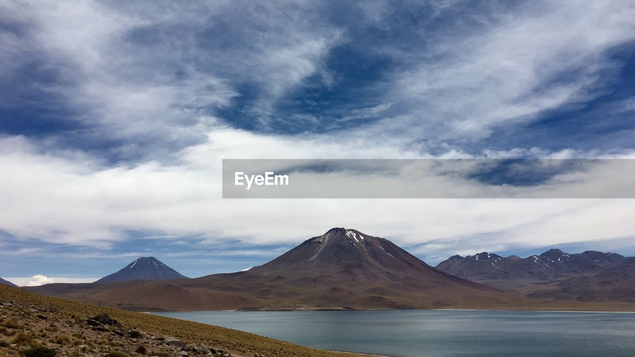 Scenic view of mountain range against cloudy sky