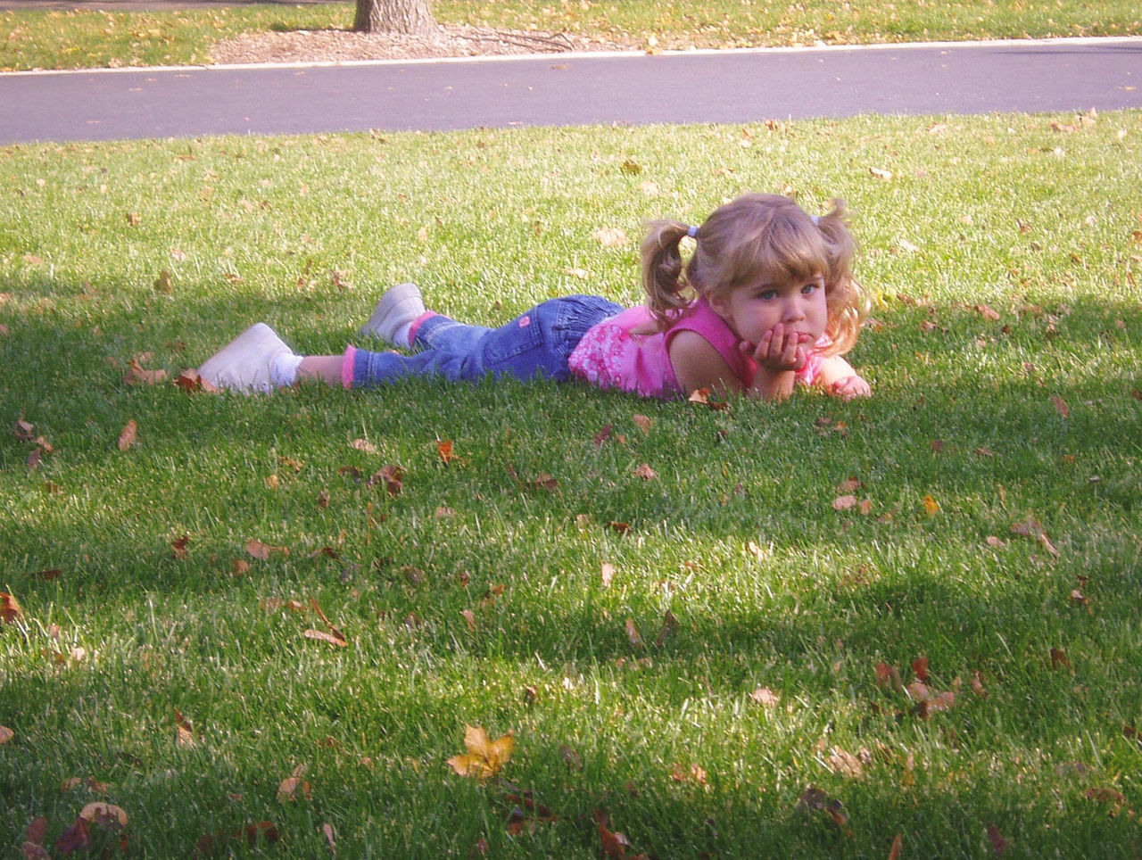 Portrait of girl relaxing on grassy field in park
