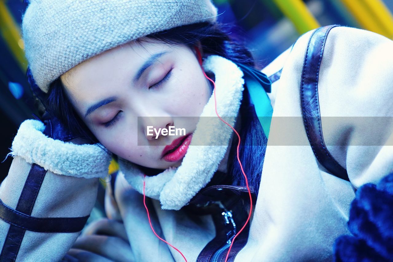 Close-up of beautiful woman in warm clothing sleeping 