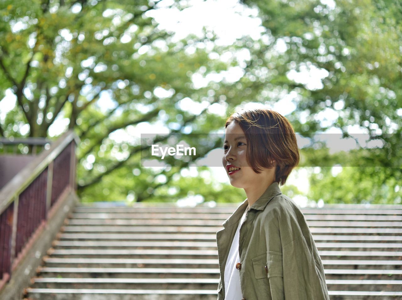 Woman looking away while standing on staircase