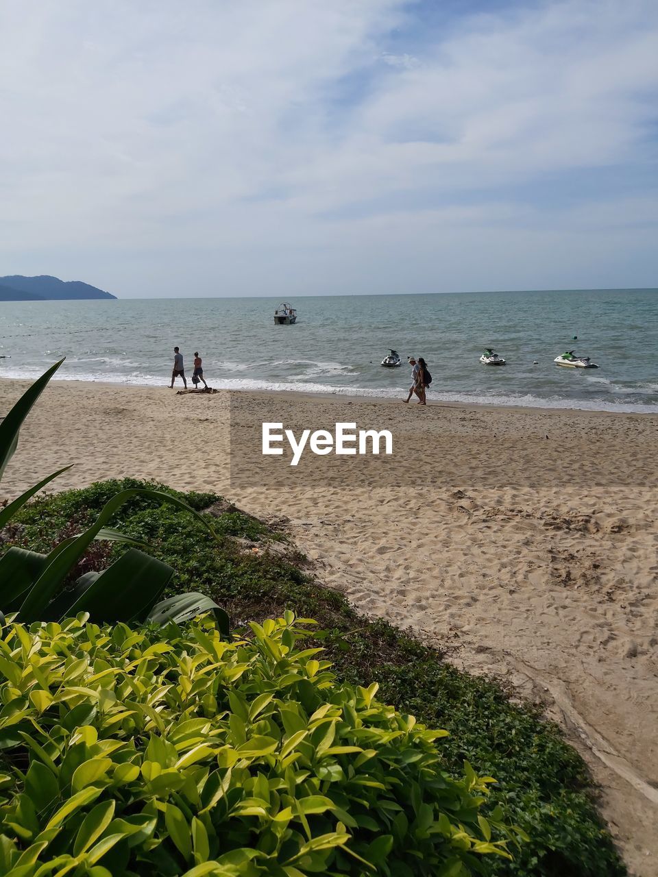 GROUP OF PEOPLE ON BEACH AGAINST SKY