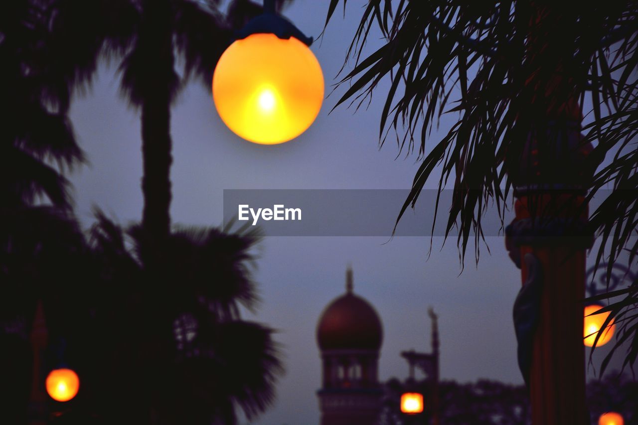 Low angle view of illuminated lantern against sky at night