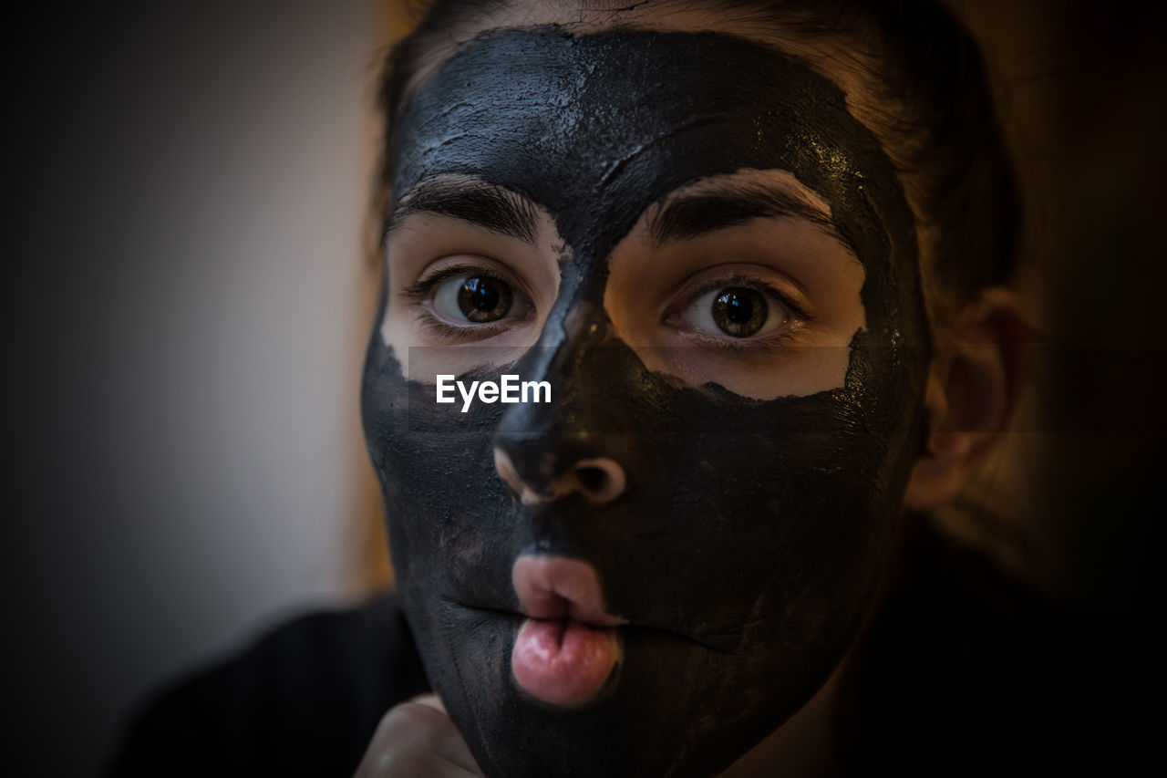 Close-up portrait of young woman with facial mask