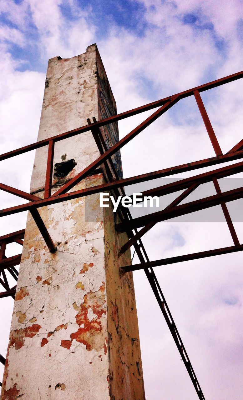 Low angle view of architectural column against cloudy sky