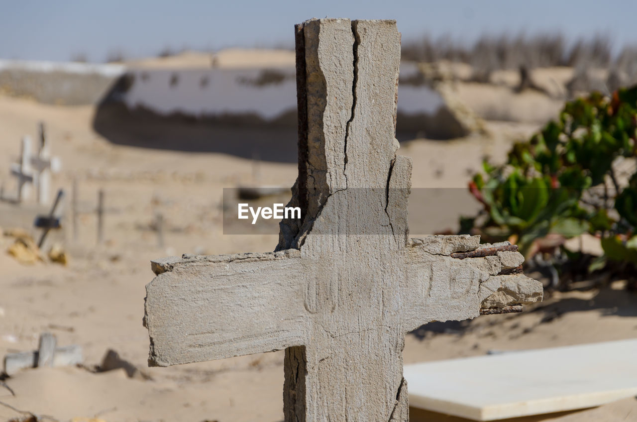 Close-up of crumbling cross at graveyard in namib desert, angola, africa