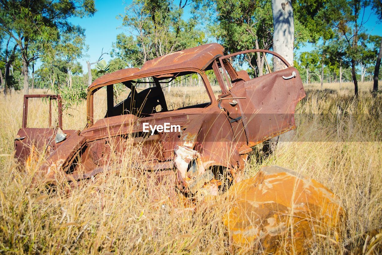 Rusty damaged car on grassy field