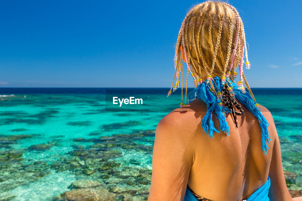 Woman at beach against sky