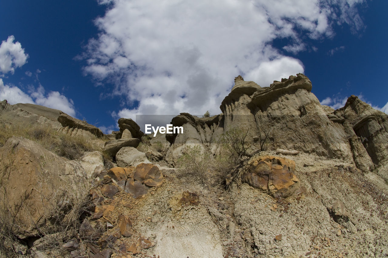 LOW ANGLE VIEW OF ROCK FORMATION ON LAND AGAINST SKY