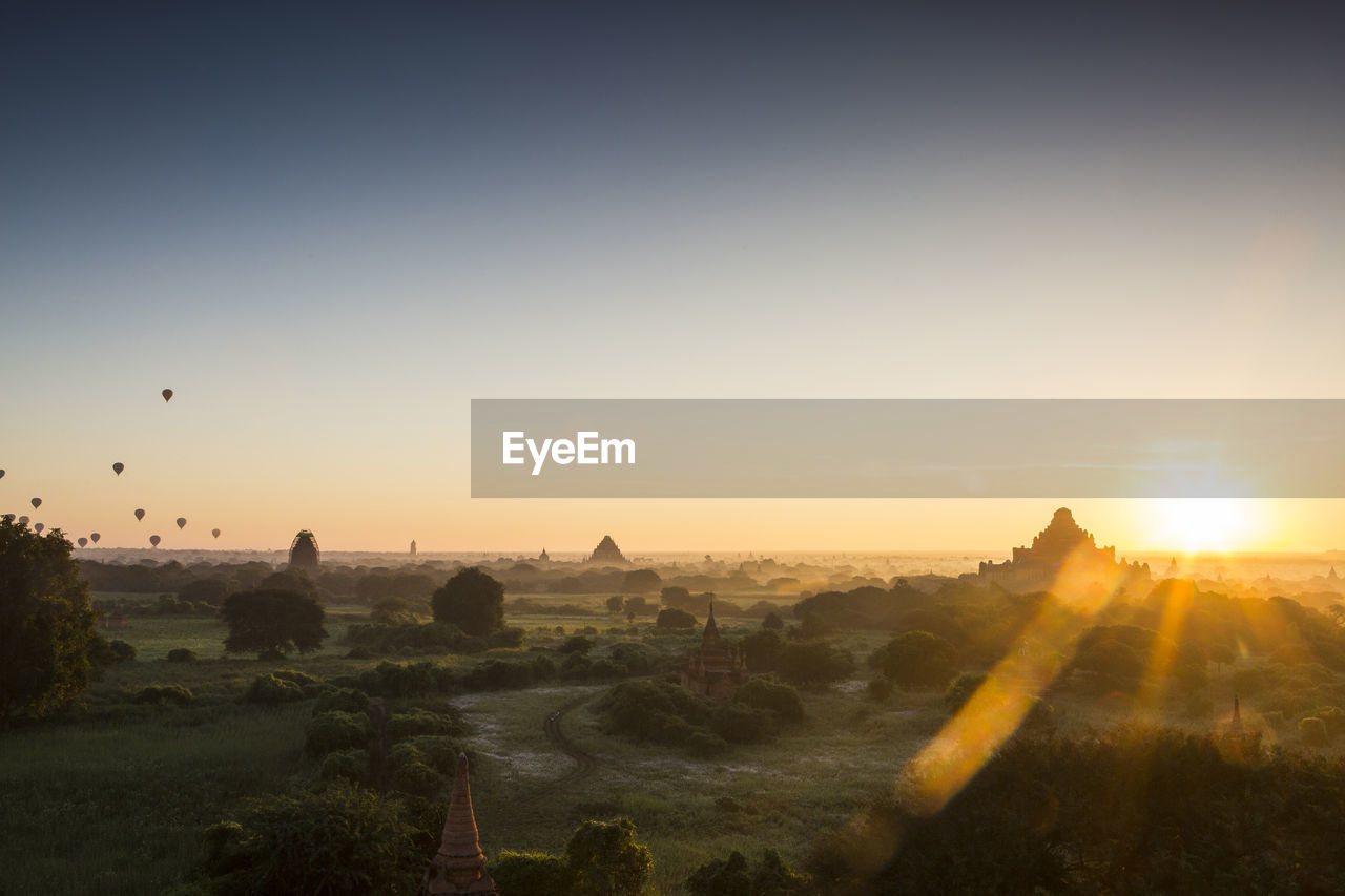 Temple on landscape against sky during sunset