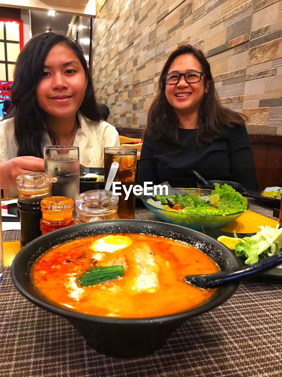 PORTRAIT OF A SMILING YOUNG WOMAN IN RESTAURANT