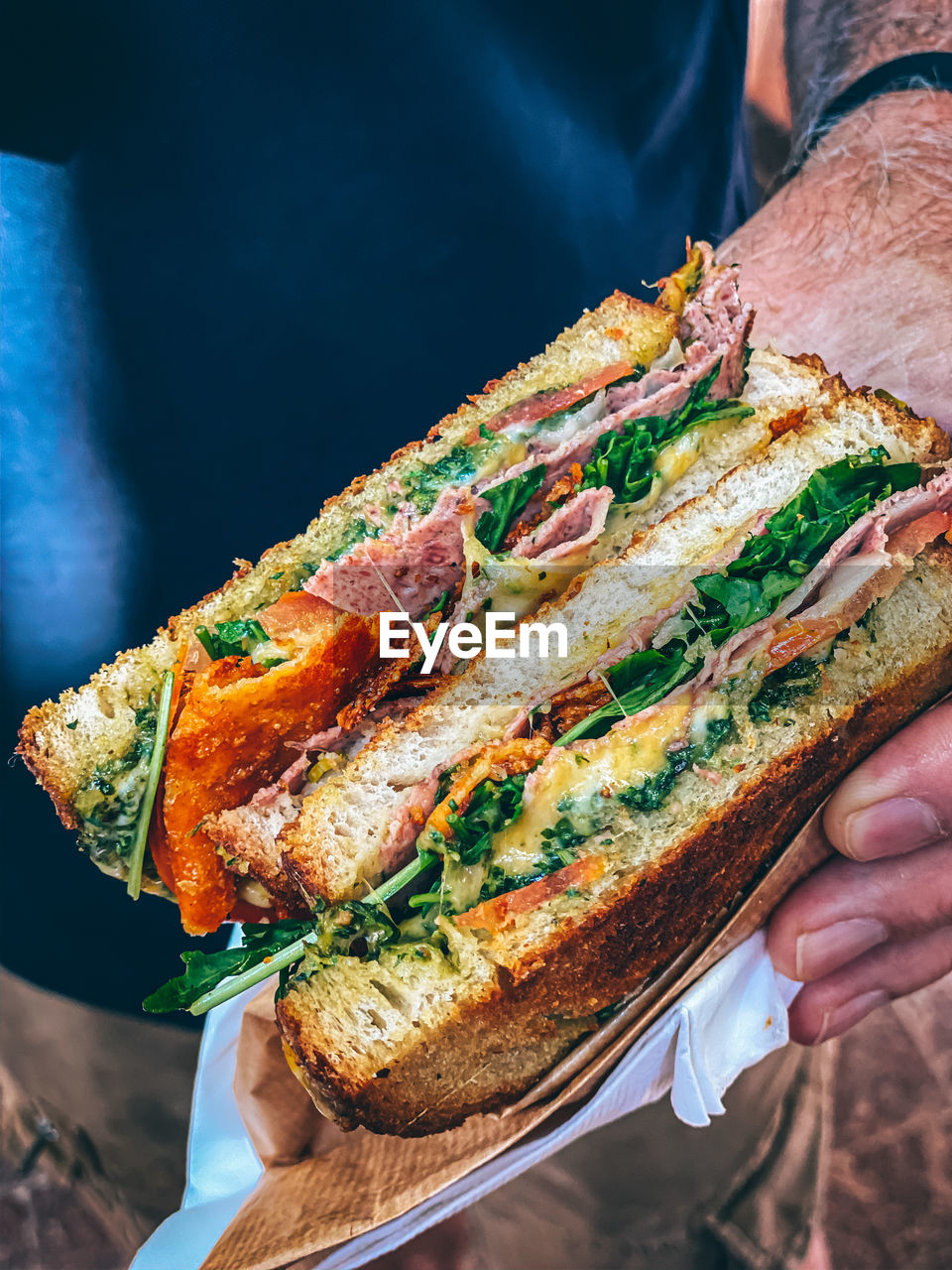 Close-up of hand holding cut toasted cheese sandwich 