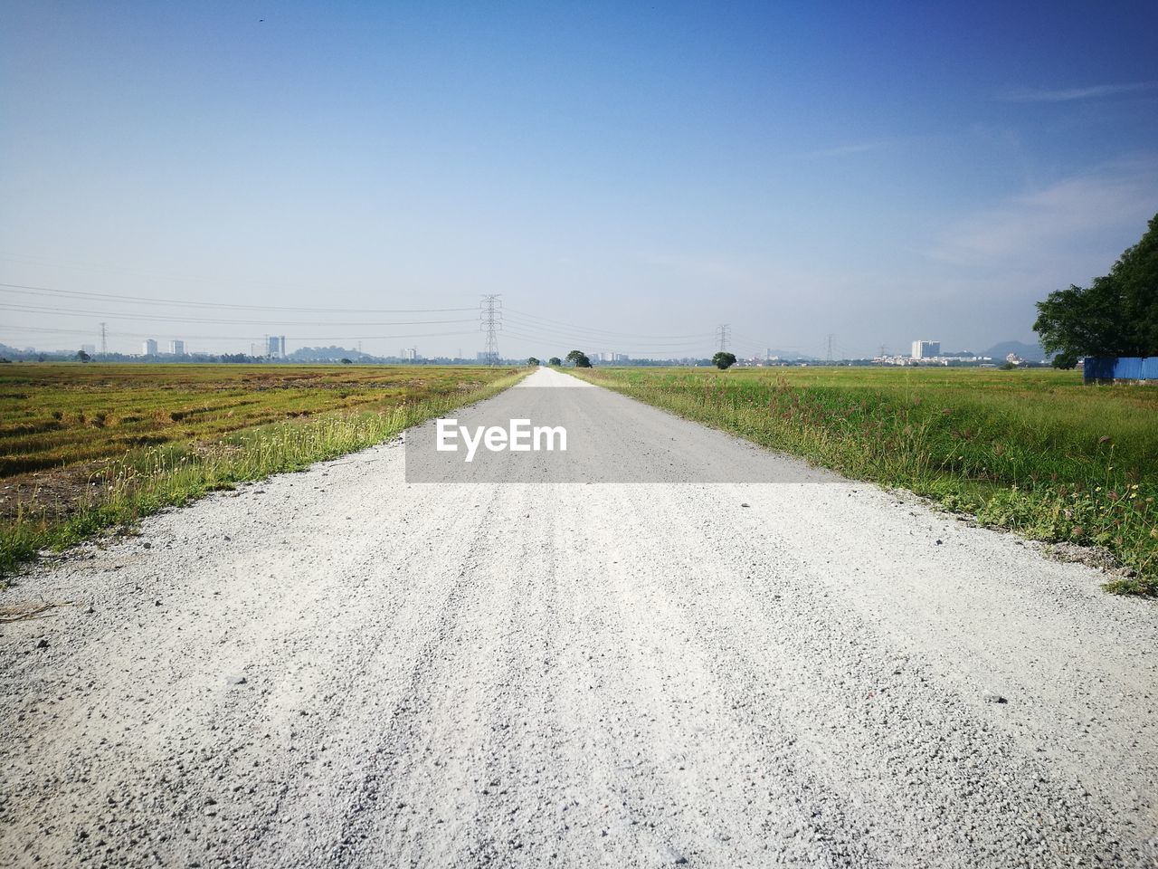 Road amidst field against sky