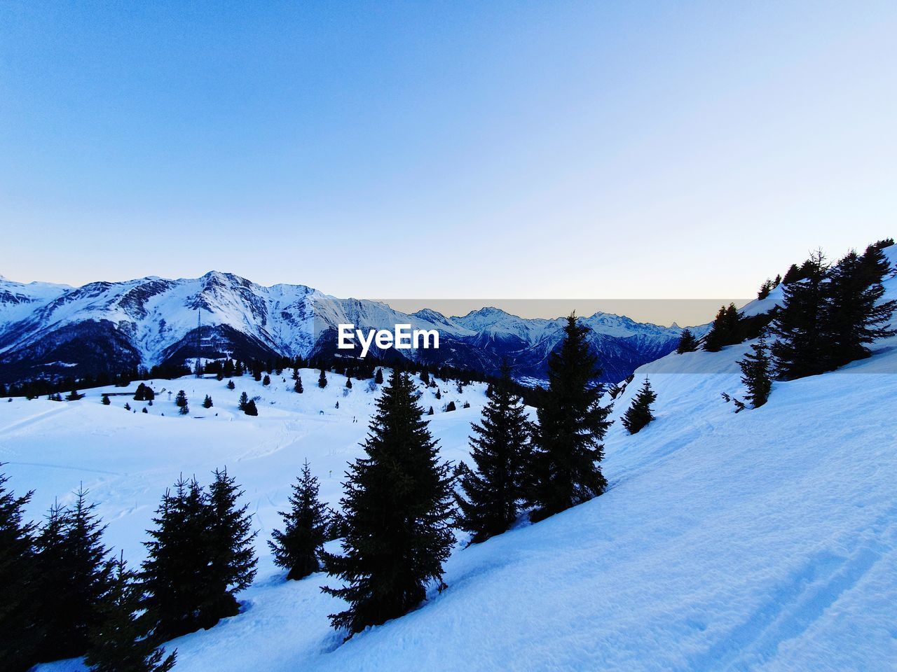 Scenic view of snow covered mountains against clear sky