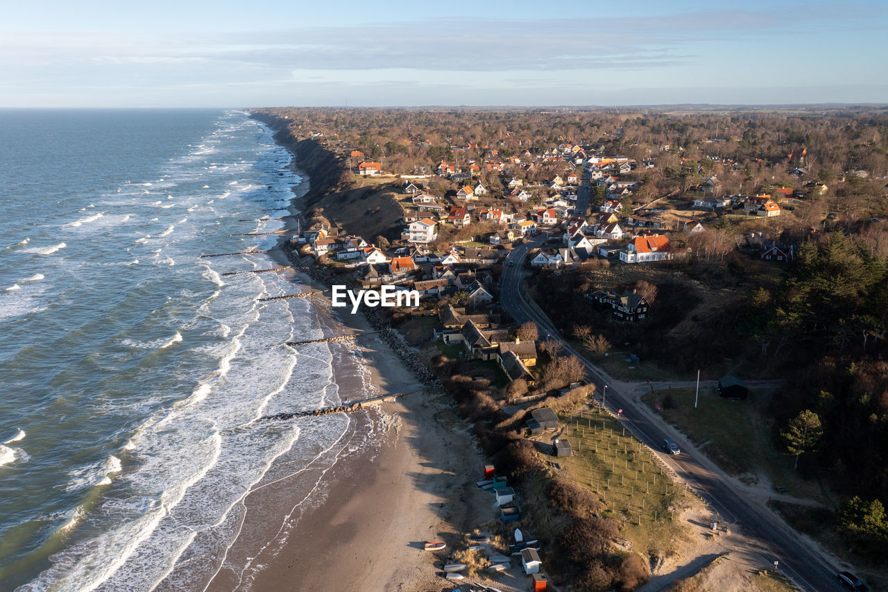 high angle view of city by sea against sky