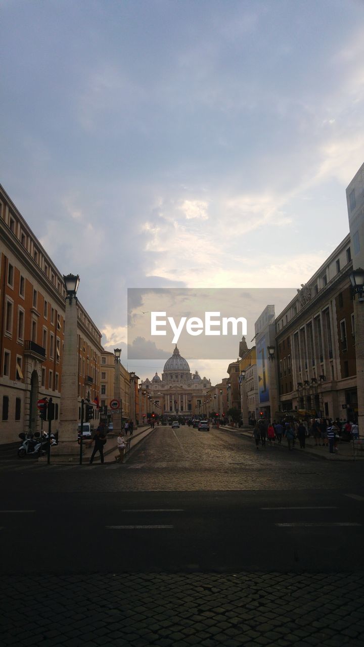 People walking on street in city against sky