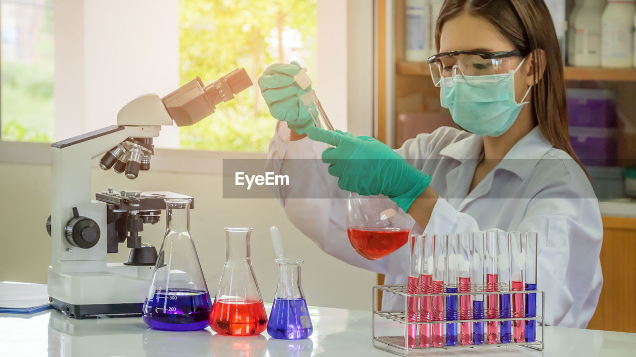 Female scientist examining chemical in laboratory