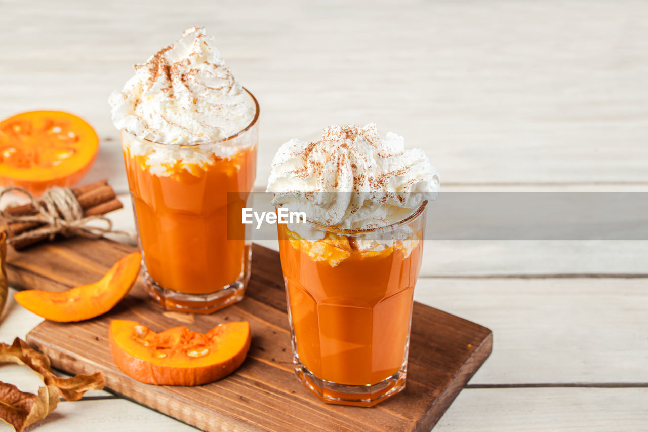 food and drink, food, soft drink, refreshment, drink, wood, healthy eating, household equipment, sweet food, fruit, glass, freshness, drinking glass, dairy, produce, sweet, orange color, studio shot, dessert, no people, table, wellbeing, frozen, orange, cold temperature, indoors