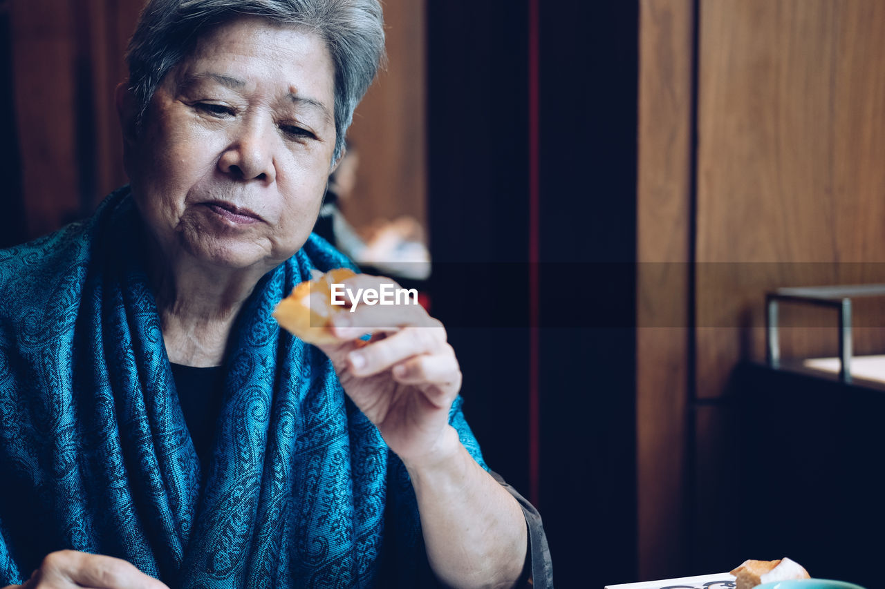 Senior woman eating breakfast at home