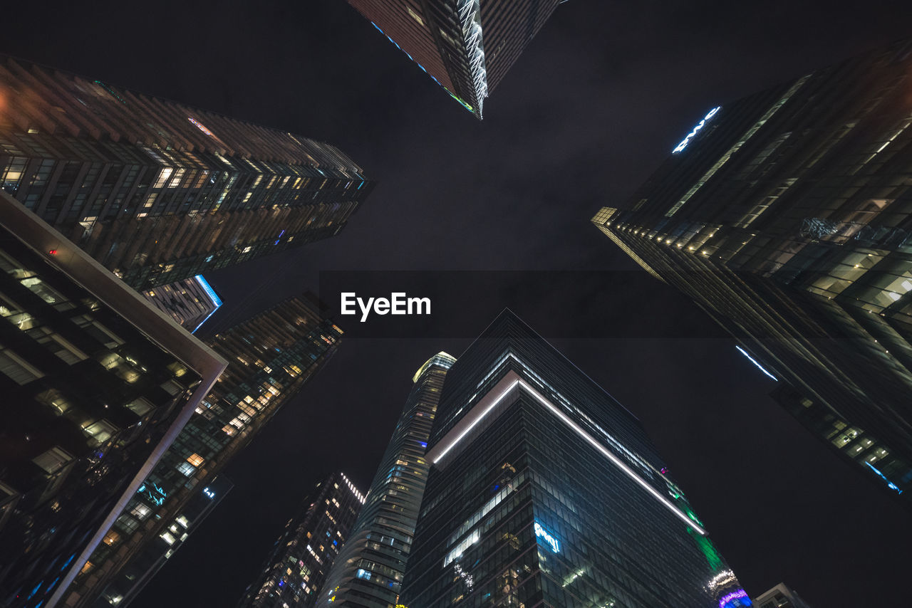 Low angle view of illuminated buildings against sky at night