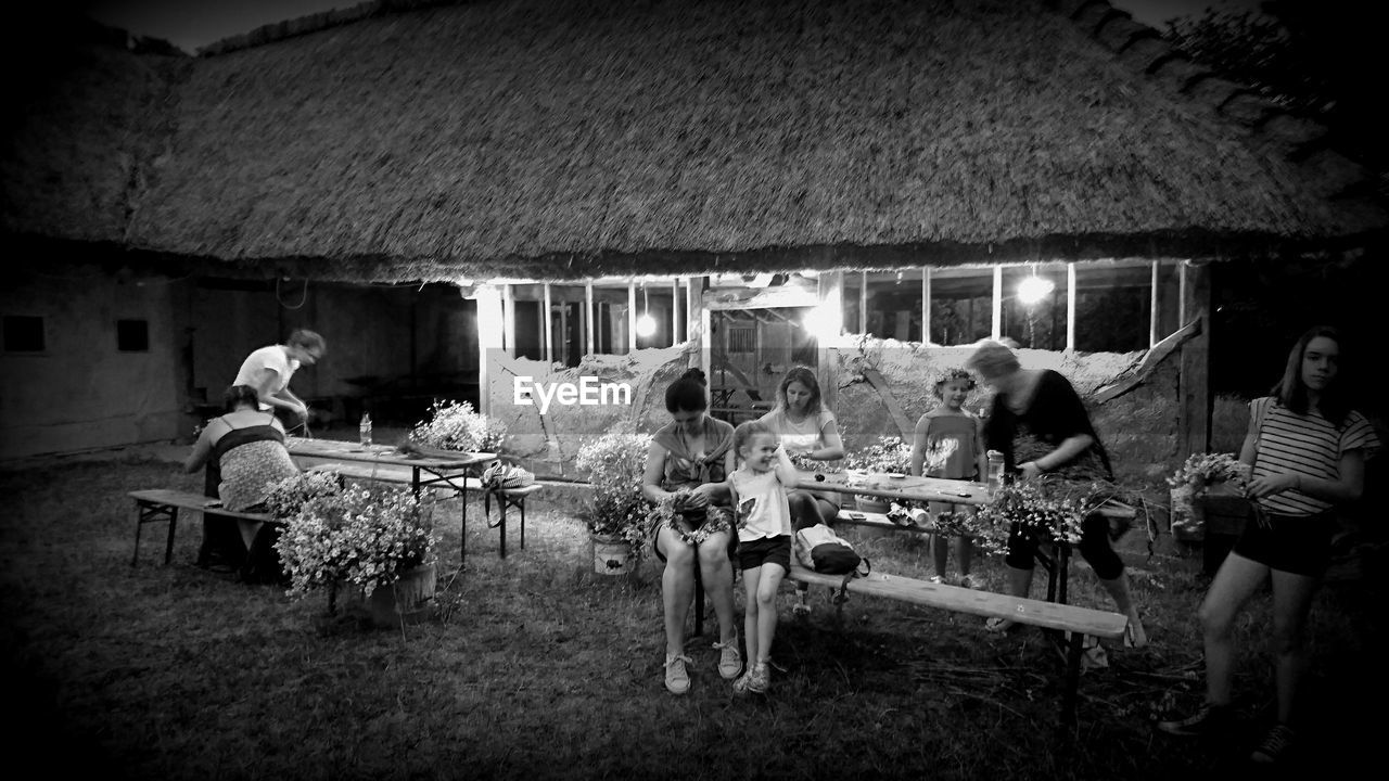 PEOPLE SITTING ON TABLE BY CHAIRS