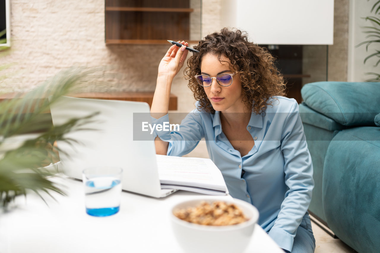 portrait of young woman wearing sunglasses while sitting at restaurant