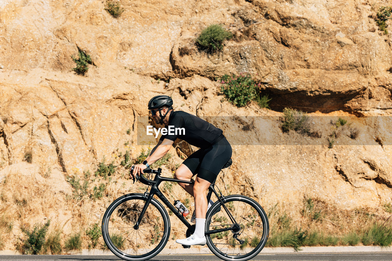 rear view of man riding bicycle on mountain