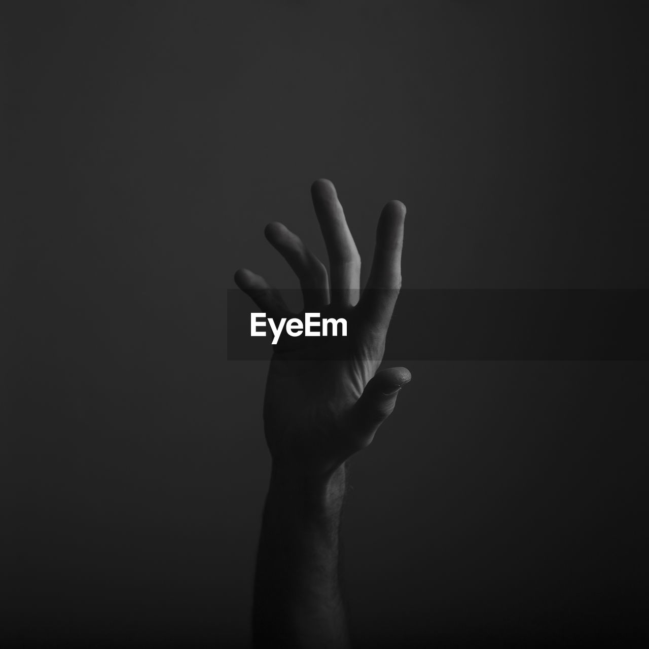 Close-up of human hand gesturing against black background