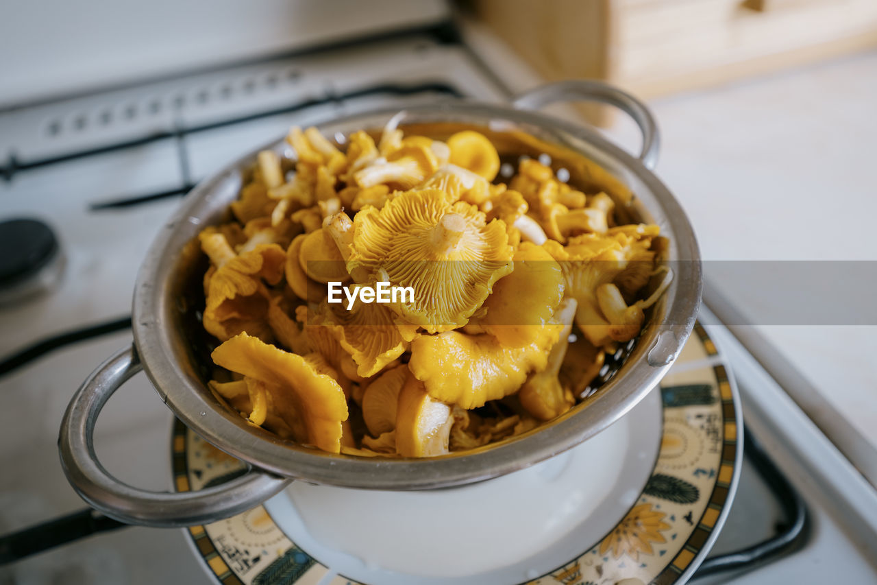 Wet chanterelles in a colander after rinsing. freshly picked mushrooms.