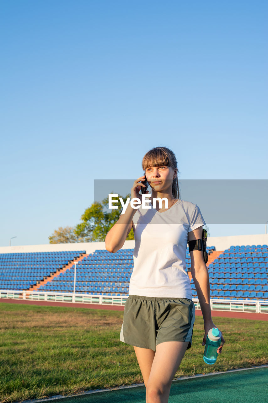 Full length of man standing on field against clear sky