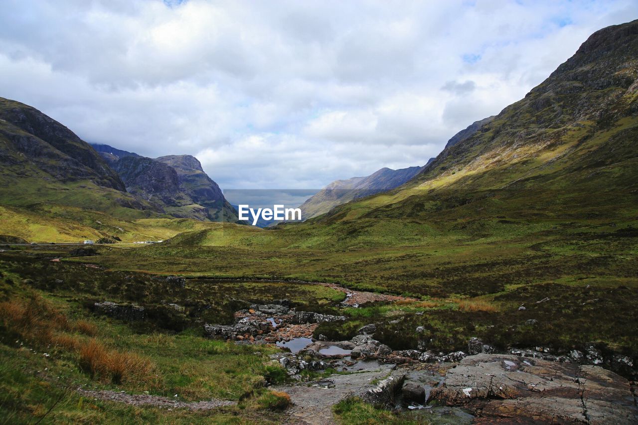 Scenic view of mountains against cloudy sky