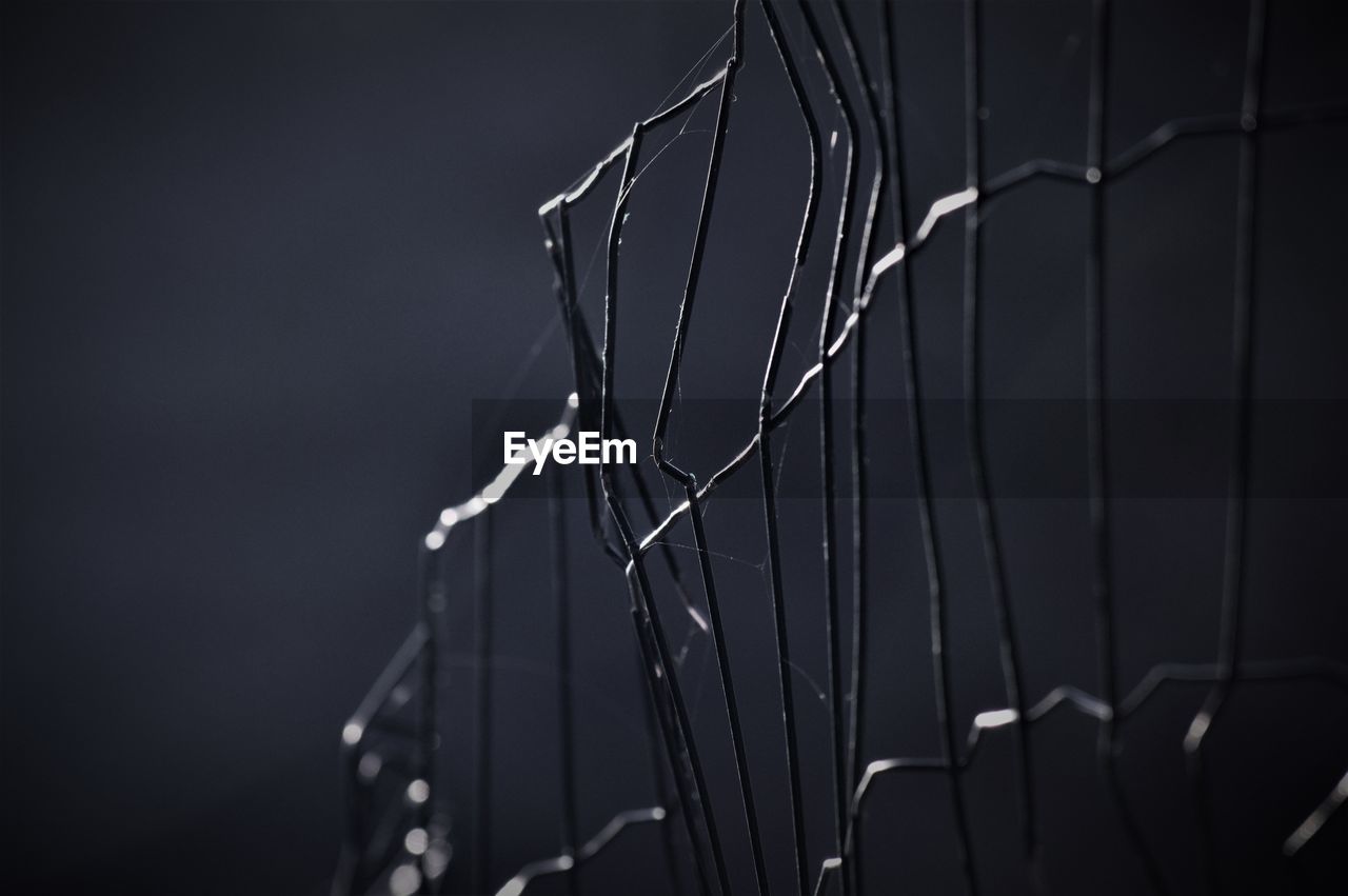 Close-up of metal fence at night