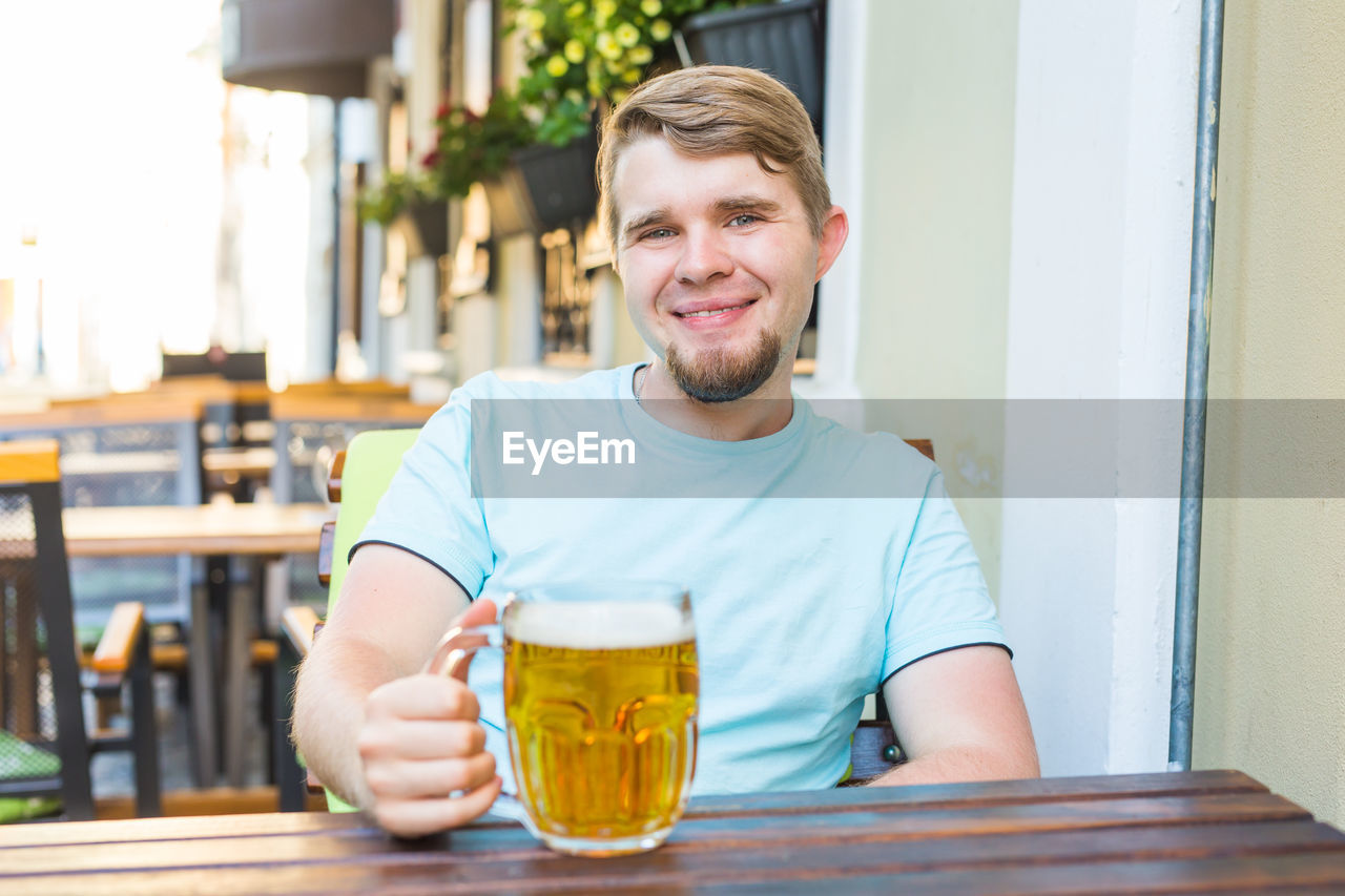 Portrait of a smiling young man sitting in restaurant
