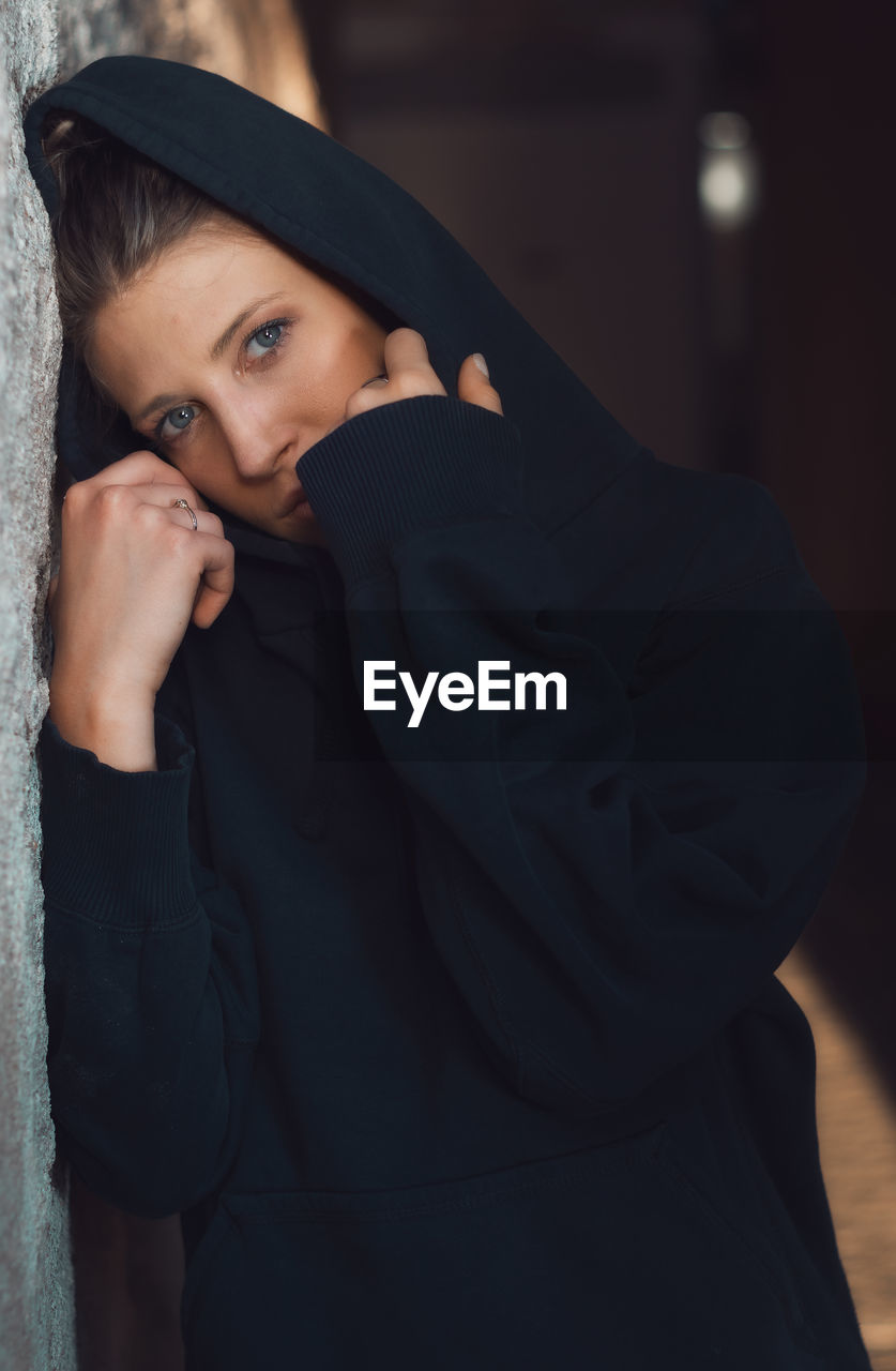 Portrait of beautiful woman standing against wall