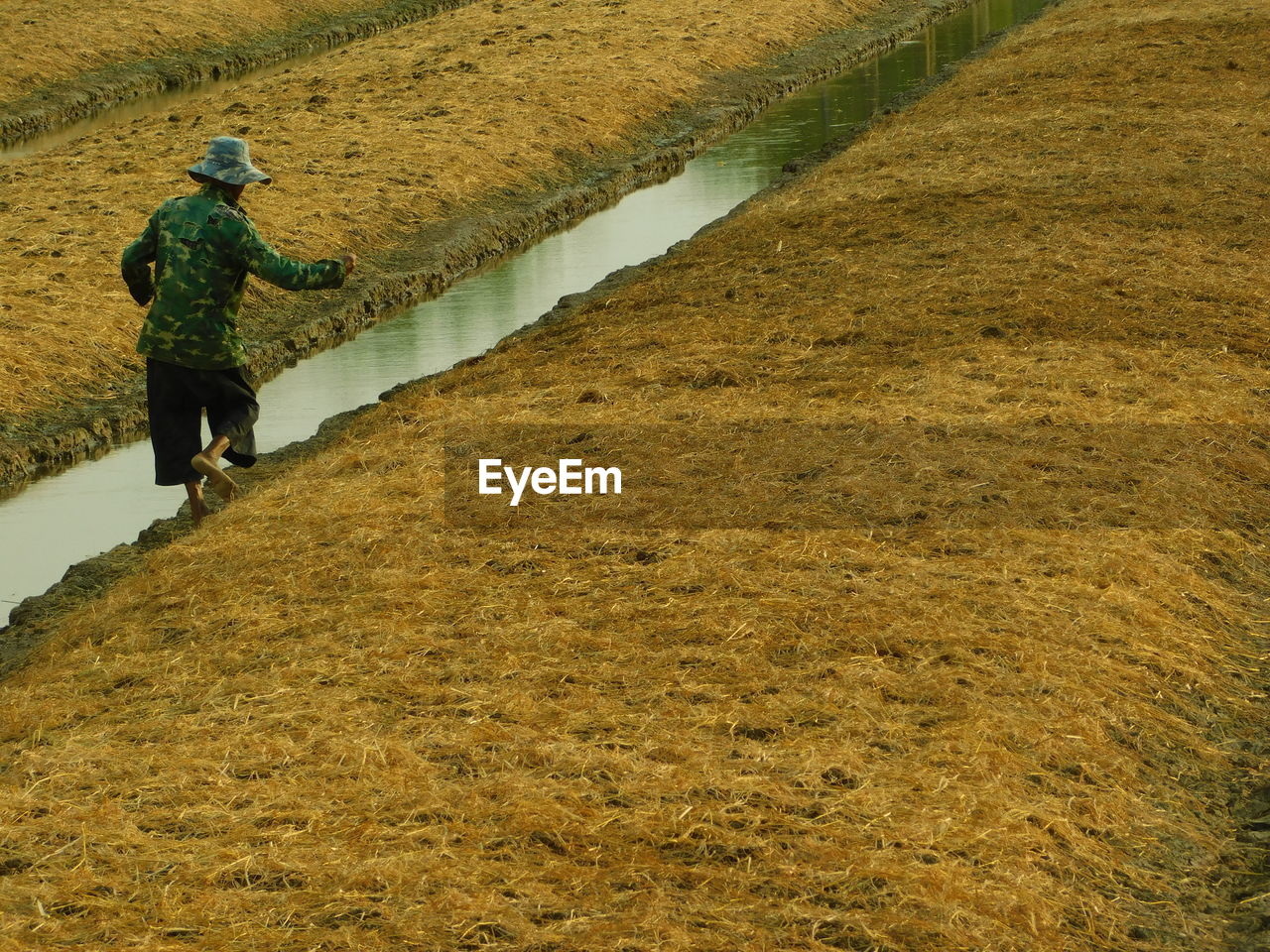 MAN WALKING ON FIELD