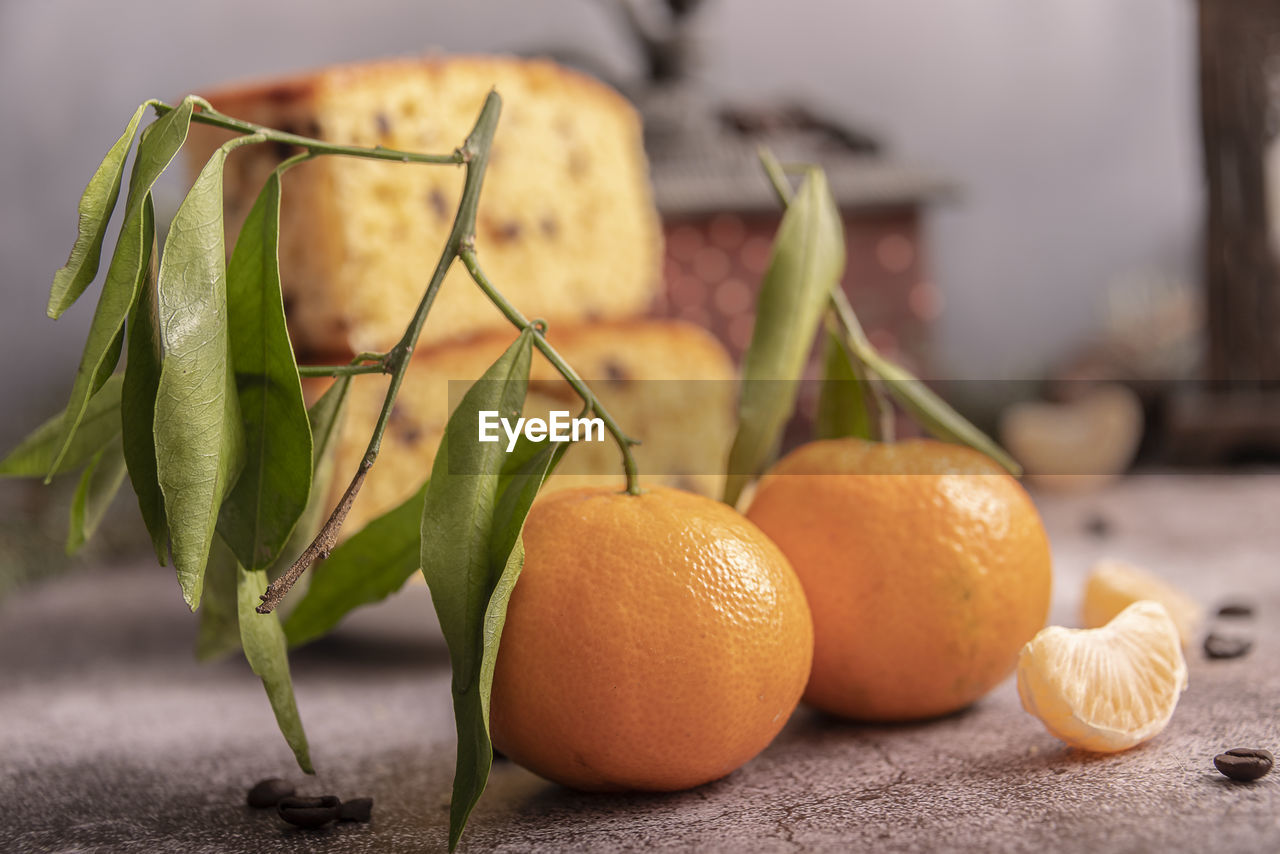 Fresh mandarin oranges fruit or tangerines with leaves on wooden table.
