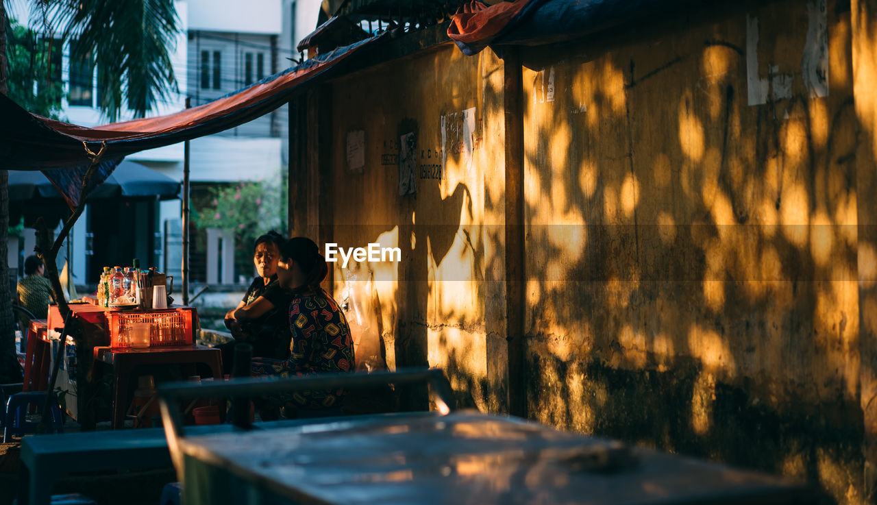 Female vendors at market stall in city during sunset