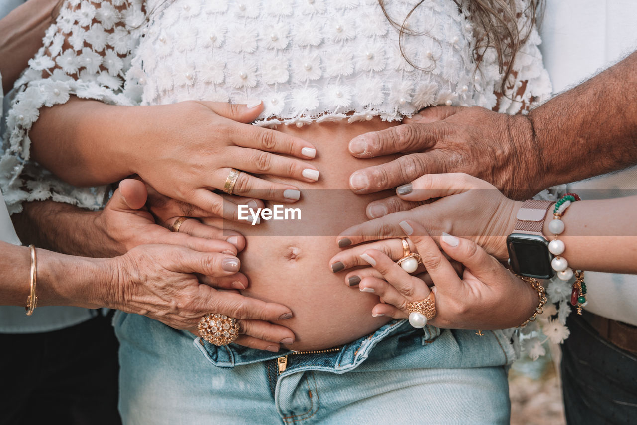 Cropped hand touching pregnant woman stomach