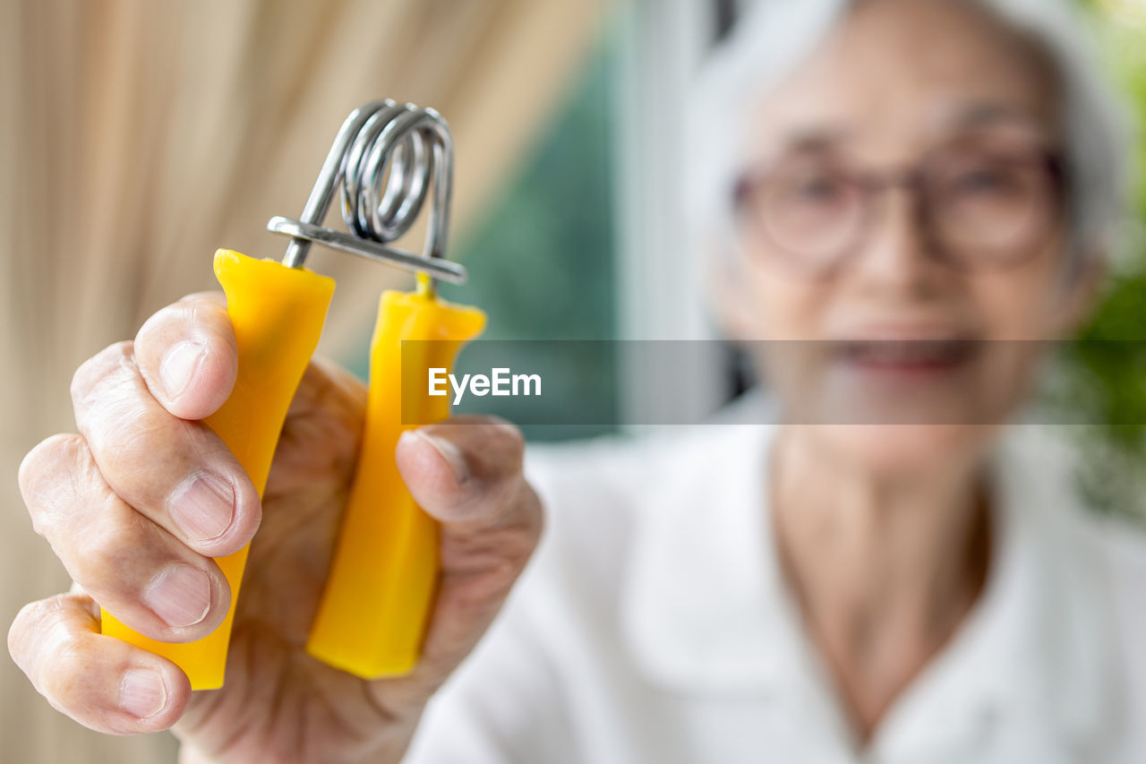 Close-up of senior woman holding squeezing equipment