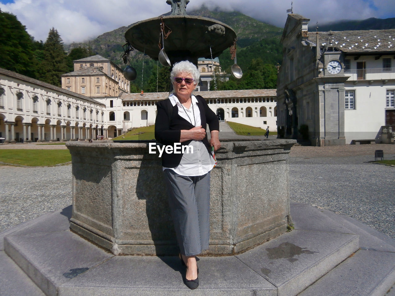 A seventy year old caucasian woman posing near a column