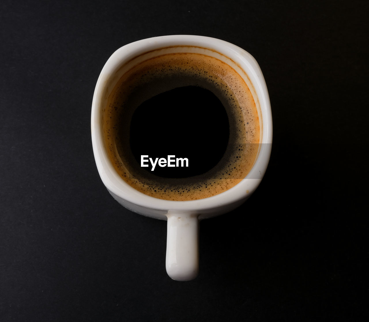 Directly above shot of coffee cup against black background