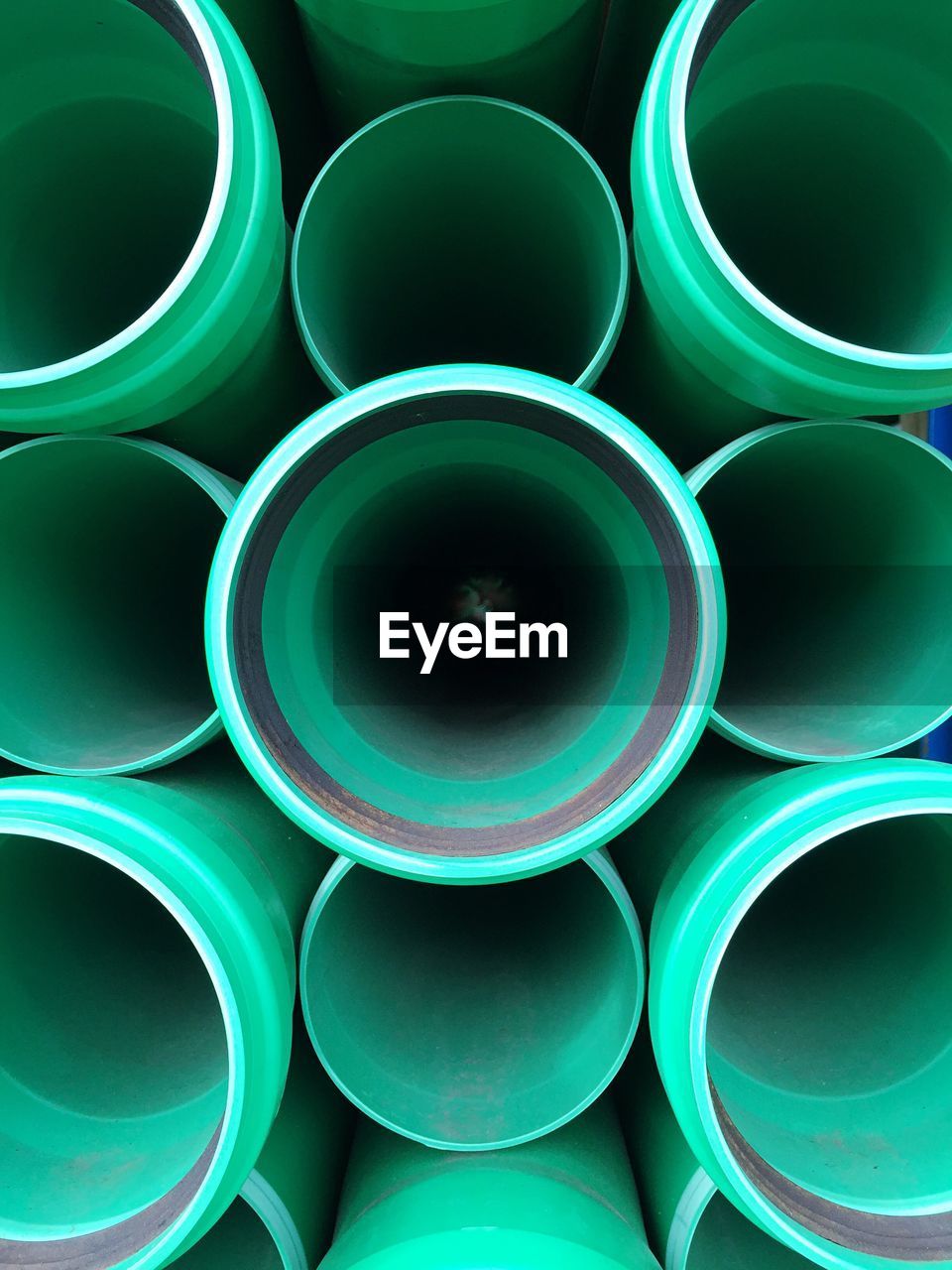 Full frame shot of stacked green pipes