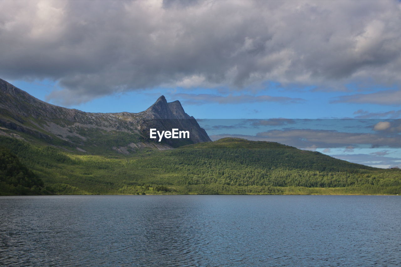 Scenic view of lake by mountain against sky