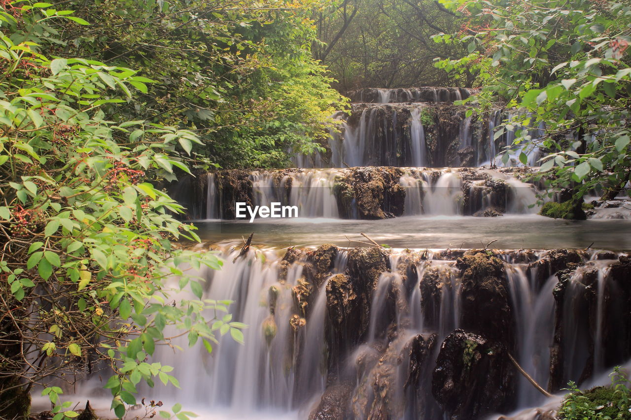 waterfall, water, beauty in nature, scenics - nature, plant, tree, nature, body of water, environment, motion, forest, water feature, watercourse, long exposure, travel destinations, land, flowing water, tourism, travel, no people, outdoors, flowing, rainforest, environmental conservation, landscape, rock, river, idyllic, tropical climate, water resources, non-urban scene, blurred motion, jungle, foliage, lush foliage, social issues