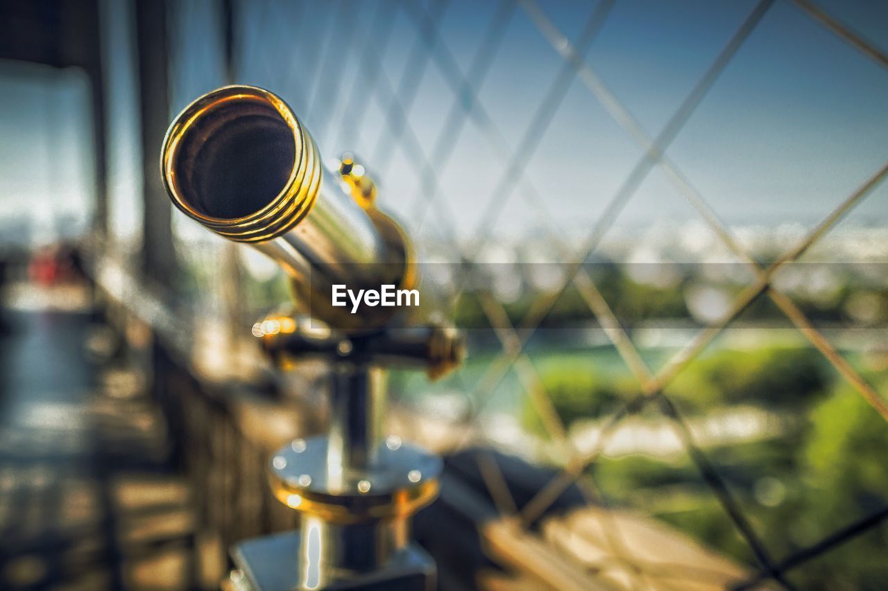 Close-up of the sightseeing telescope and metal fence against sky. view from top of eiffel tower 