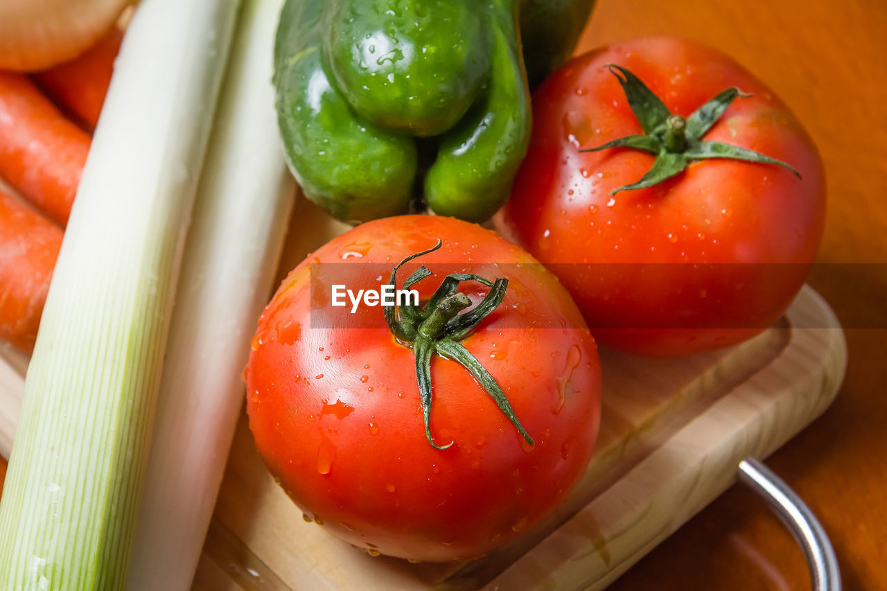 Fresh vegetables on cutting board in a wooden kitchen table