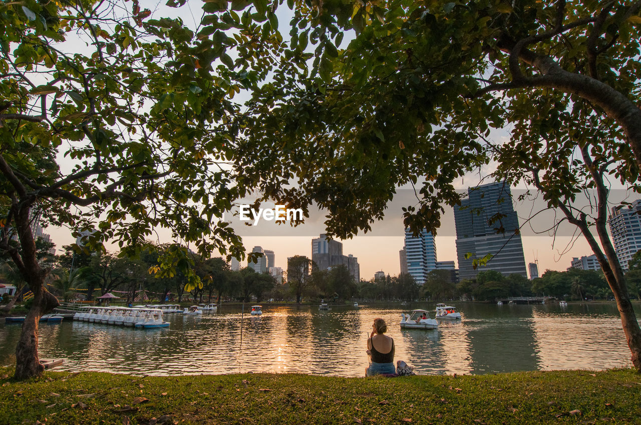 PEOPLE SITTING BY RIVER