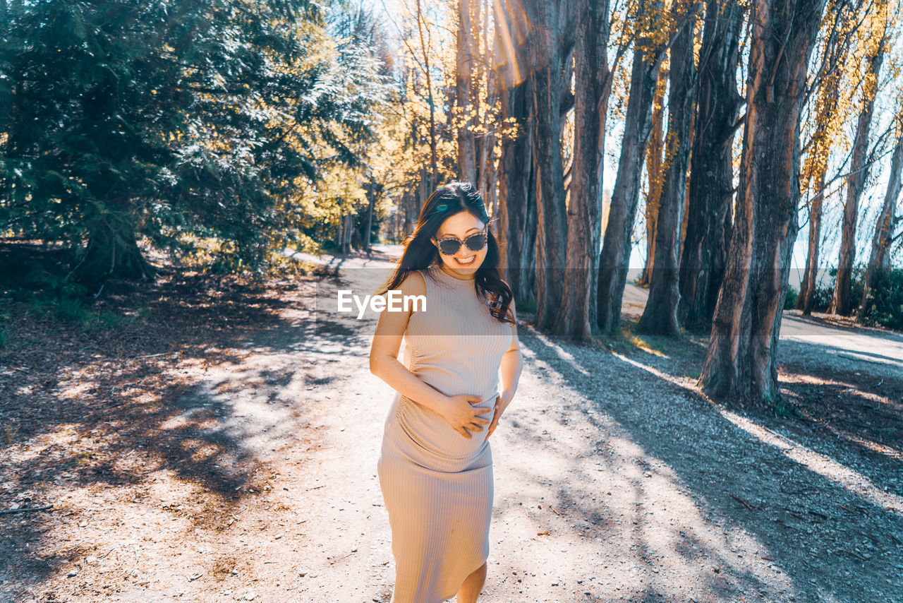 Portrait of young woman standing in forest