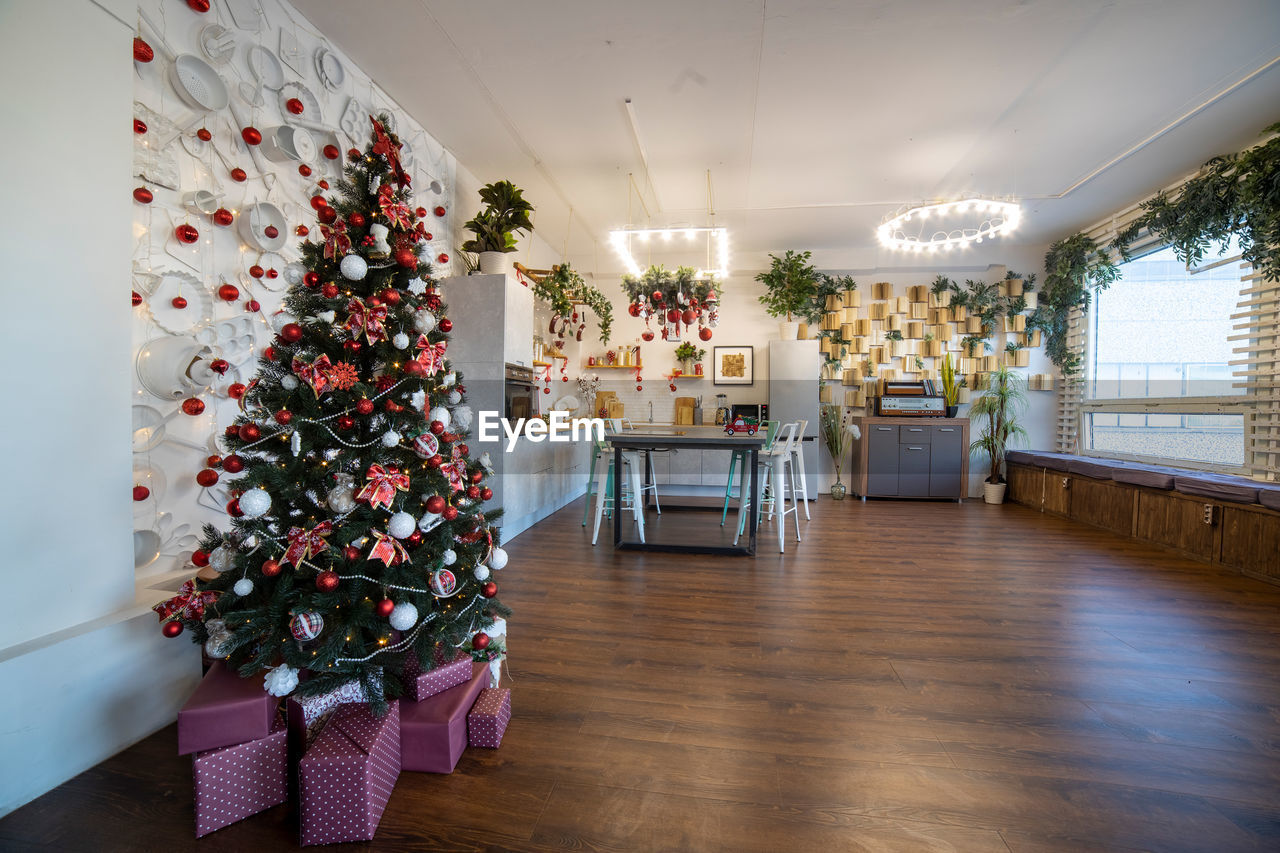 Kitchen decorated with pine garlands and christmas toys, no people